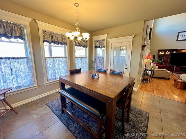 dining room with baseboards, tile patterned flooring, and a notable chandelier