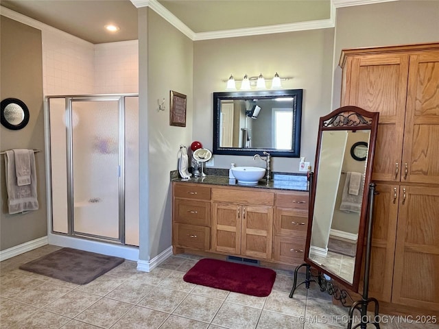 full bath with baseboards, tile patterned flooring, crown molding, vanity, and a shower stall