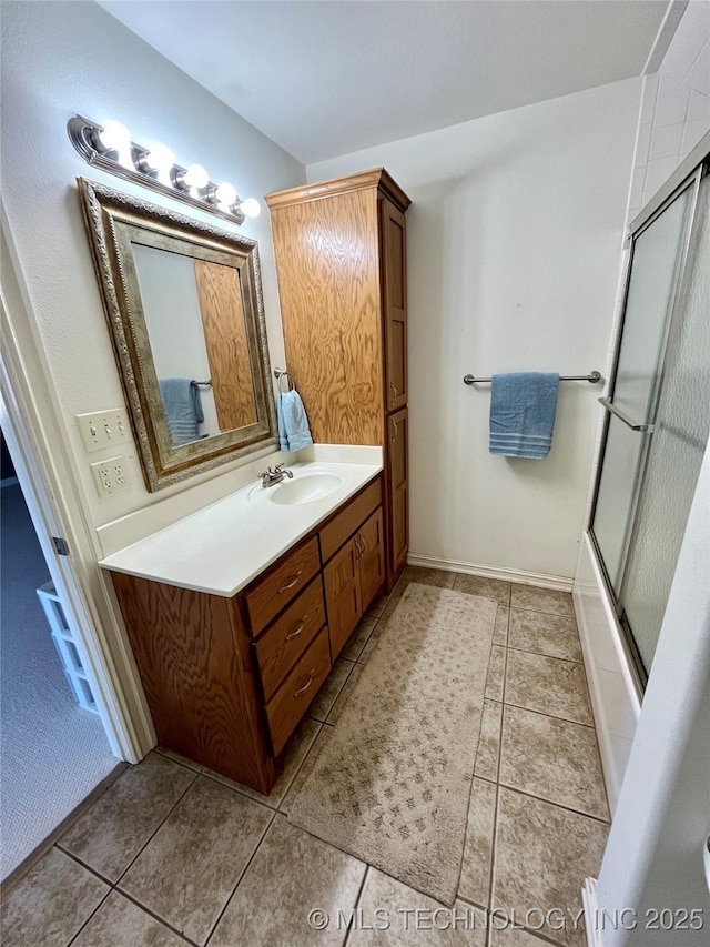 bathroom featuring tile patterned flooring, enclosed tub / shower combo, and vanity