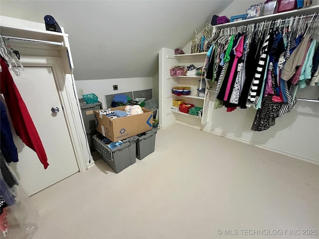 spacious closet featuring carpet floors and vaulted ceiling