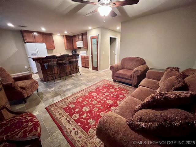 living room featuring baseboards, a ceiling fan, and recessed lighting