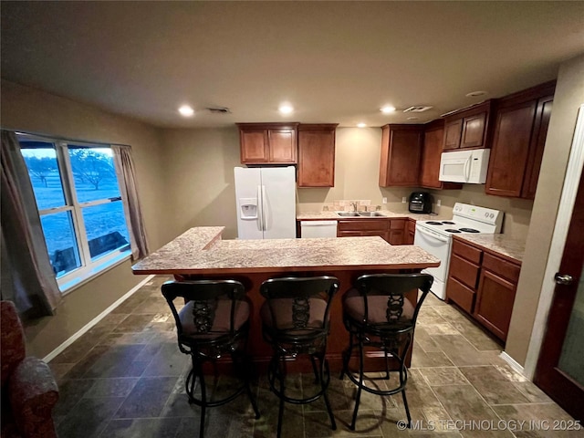 kitchen featuring light countertops, white appliances, a sink, and recessed lighting