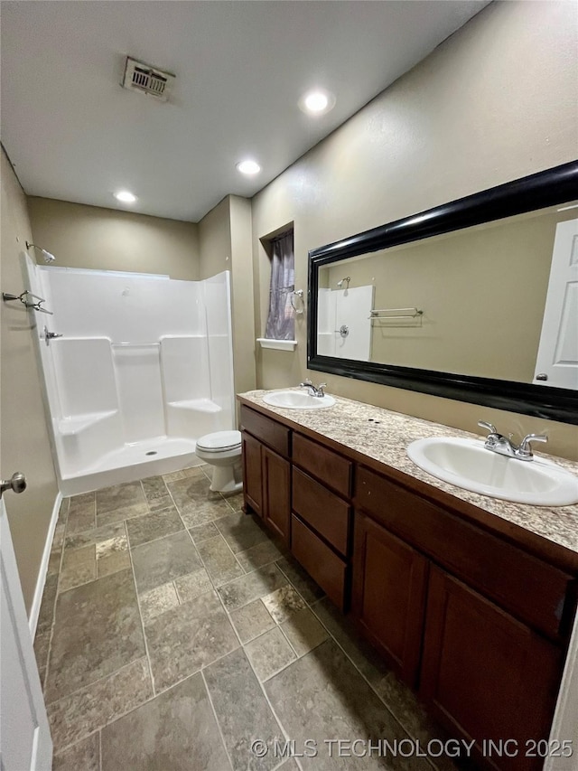 full bath featuring a shower, visible vents, a sink, and double vanity