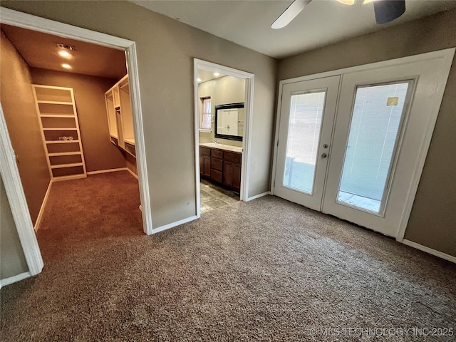 doorway featuring french doors, carpet flooring, ceiling fan, and baseboards