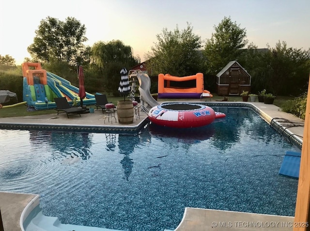 outdoor pool featuring an outbuilding and a patio