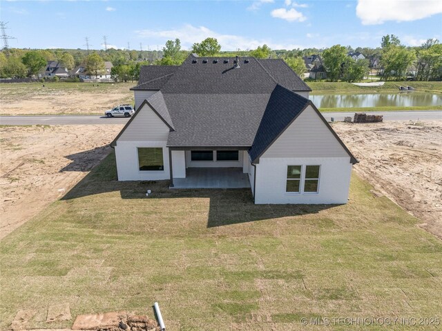 2719 E 135th Dr S, Bixby, OK 74008 - view of front facade featuring a shingled roof, a front yard, and a water view