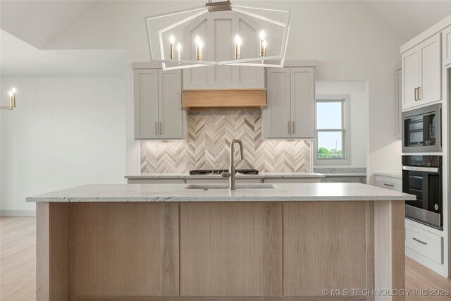 2719 E 135th Dr S, Bixby, OK 74008 - kitchen with oven, built in microwave, backsplash, lofted ceiling, and an island with sink