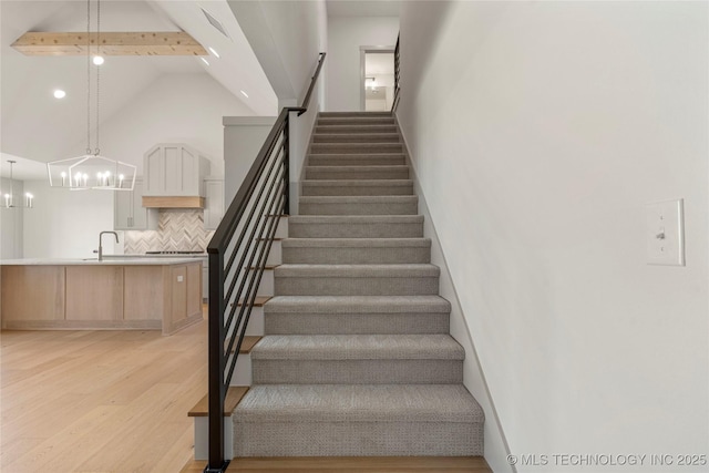 2719 E 135th Dr S, Bixby, OK 74008 - staircase with an inviting chandelier, wood finished floors, high vaulted ceiling, and recessed lighting