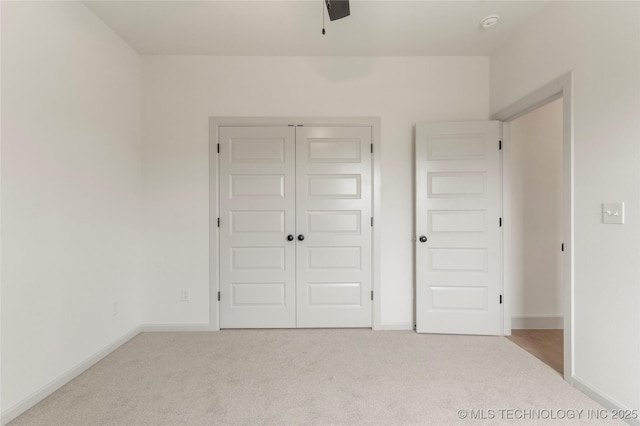 unfurnished bedroom featuring a closet, ceiling fan, carpet floors, and baseboards