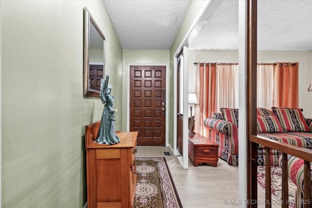 foyer entrance featuring light wood-type flooring and a textured ceiling