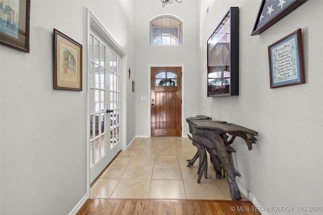 entryway featuring light tile patterned floors, french doors, and baseboards