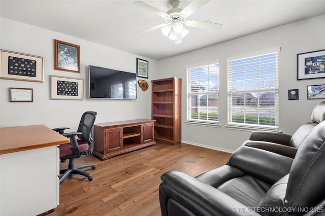 home office with light wood-style floors, baseboards, and ceiling fan