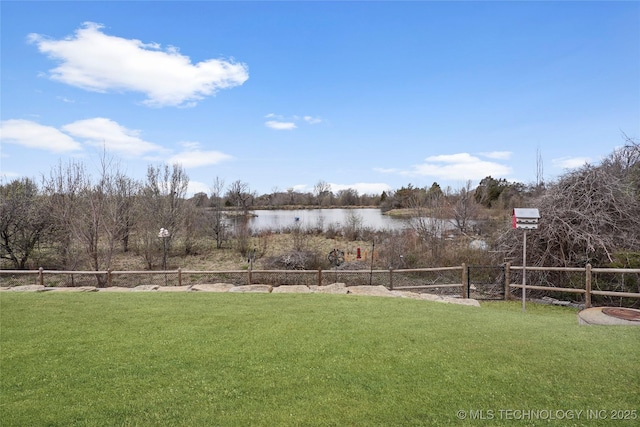 view of yard featuring a water view and fence