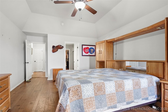 bedroom with baseboards, a ceiling fan, lofted ceiling, and hardwood / wood-style flooring