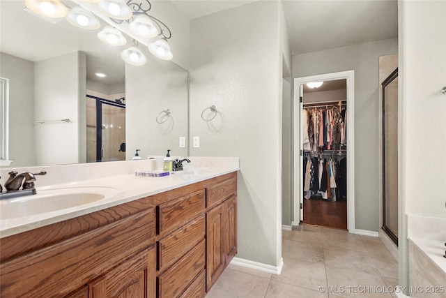 full bathroom with a sink, a walk in closet, and a shower stall