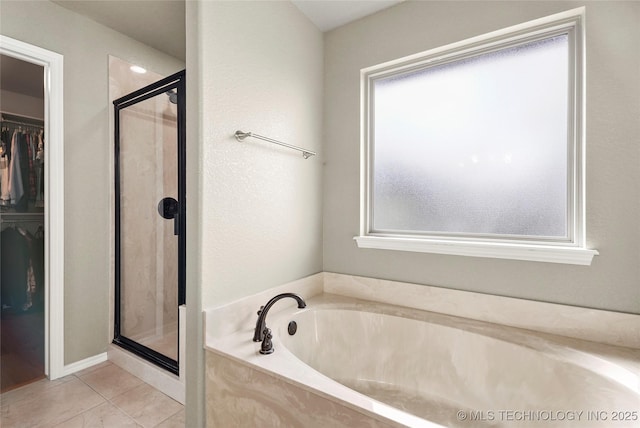 full bathroom featuring tile patterned floors, a walk in closet, a stall shower, and a bath