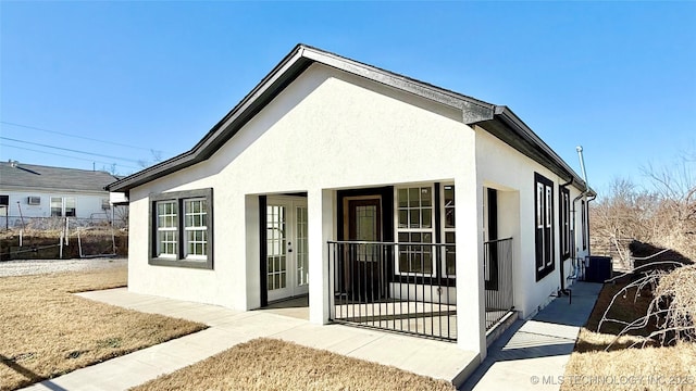 rear view of property with central AC, a patio, fence, and stucco siding