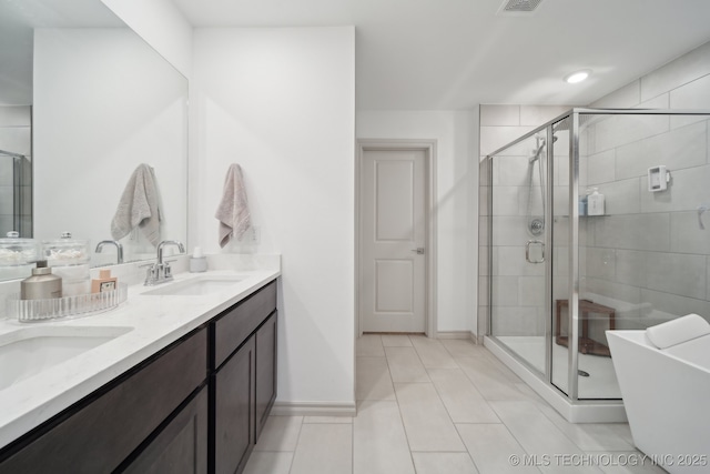 bathroom featuring baseboards, double vanity, a sink, and a shower stall