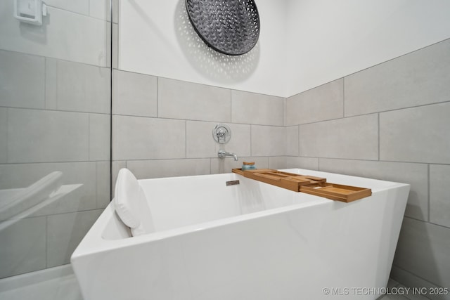 full bath with a bath and tile walls