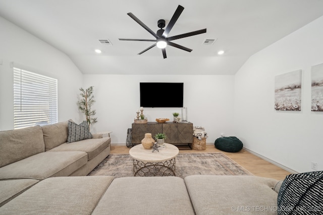 living area with lofted ceiling, ceiling fan, and visible vents