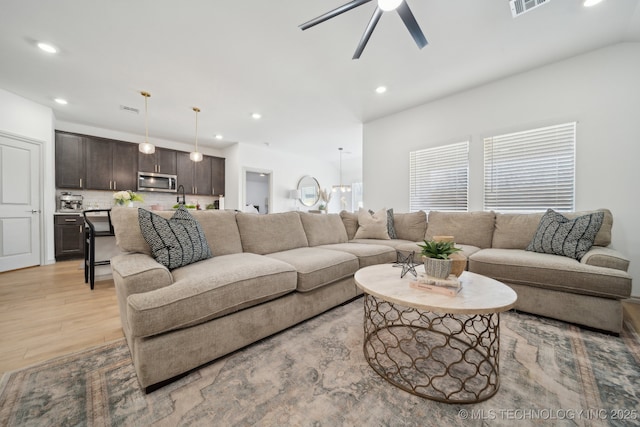 living area with light wood-style floors, visible vents, a ceiling fan, and recessed lighting