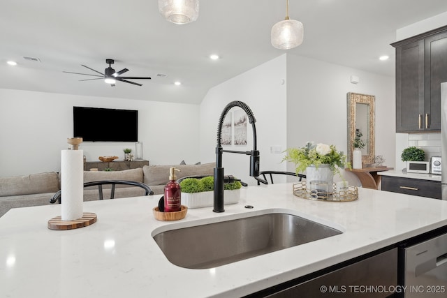 kitchen featuring visible vents, a sink, light stone countertops, pendant lighting, and stainless steel dishwasher