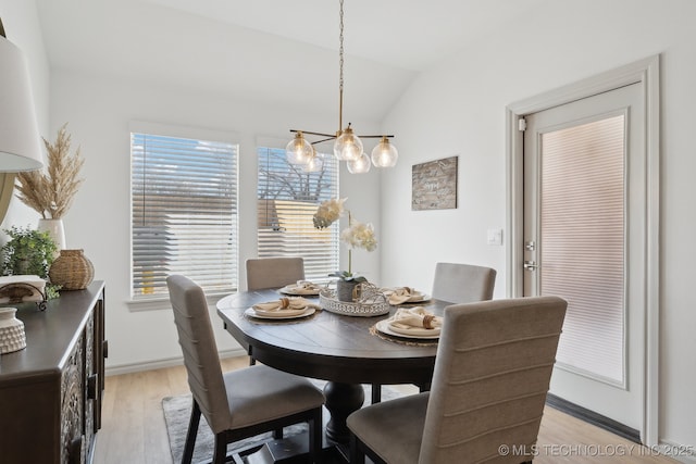 dining room featuring vaulted ceiling, light wood-style flooring, and baseboards