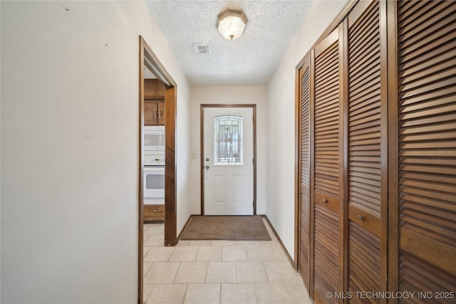 doorway to outside with visible vents and a textured ceiling