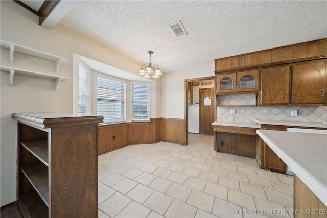 kitchen with a wainscoted wall, visible vents, open shelves, light countertops, and a chandelier