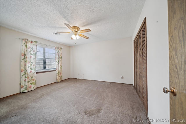 unfurnished bedroom with carpet, visible vents, a closet, and a textured ceiling