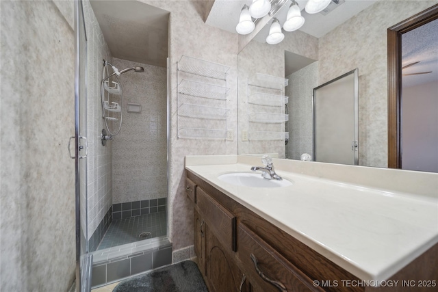 bathroom with a chandelier, visible vents, a shower stall, and vanity