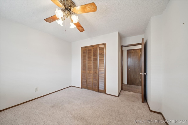 unfurnished bedroom with a closet, light colored carpet, a textured ceiling, and baseboards