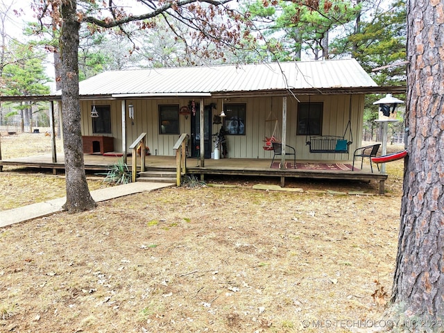 view of front of property featuring board and batten siding, covered porch, and metal roof