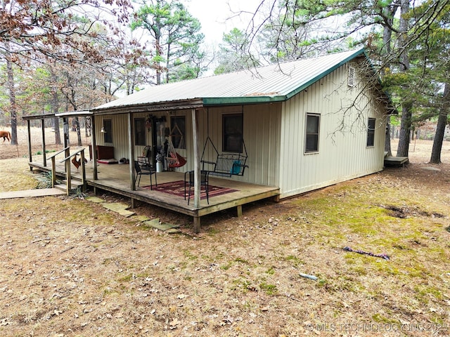 rear view of property featuring metal roof