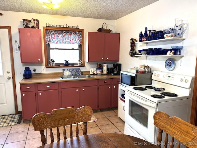 kitchen featuring red cabinets, stainless steel microwave, white electric stove, and a sink