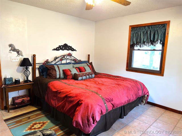 tiled bedroom with ceiling fan, a textured ceiling, and baseboards