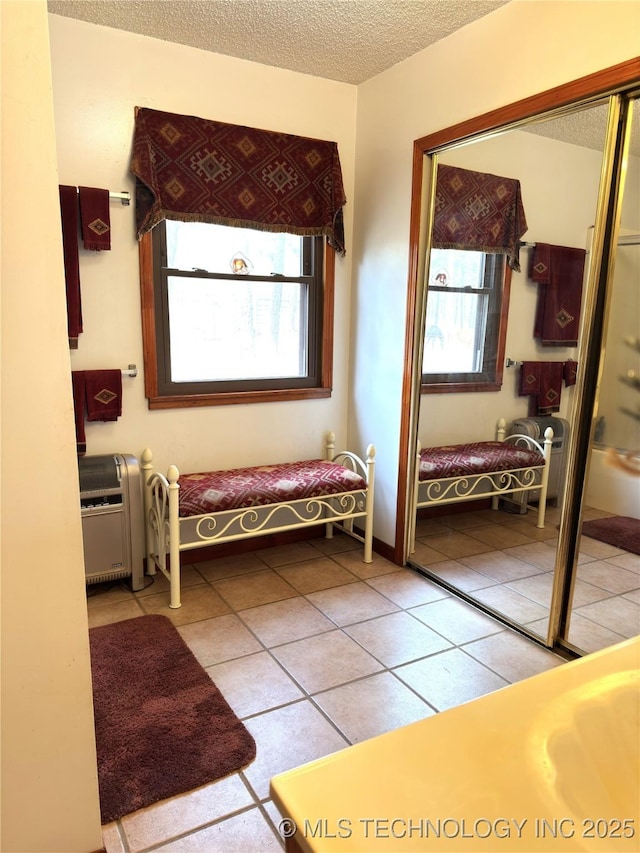 interior space with a healthy amount of sunlight, a textured ceiling, and tile patterned floors