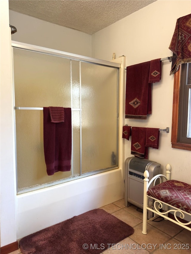 bathroom with shower / bath combination with glass door, a textured ceiling, and tile patterned floors