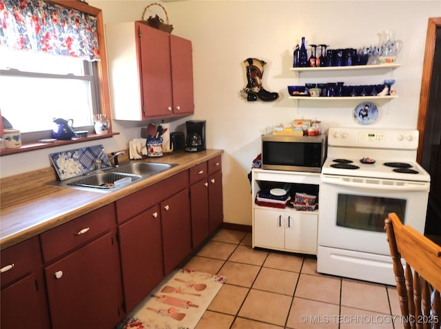 kitchen featuring light tile patterned floors, a sink, electric stove, light countertops, and stainless steel microwave