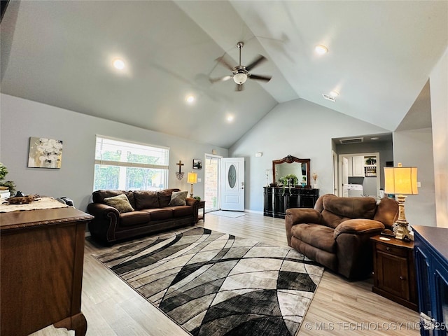 living room with high vaulted ceiling, light wood finished floors, and a ceiling fan