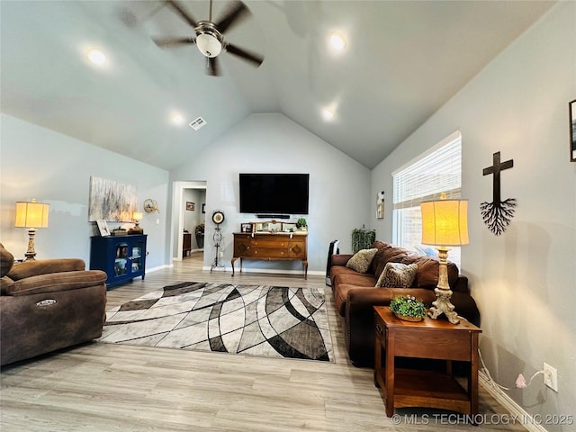 living area with light wood finished floors, visible vents, a ceiling fan, vaulted ceiling, and baseboards