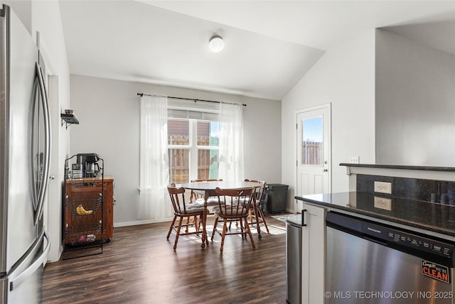 dining area featuring baseboards, lofted ceiling, and dark wood-style floors