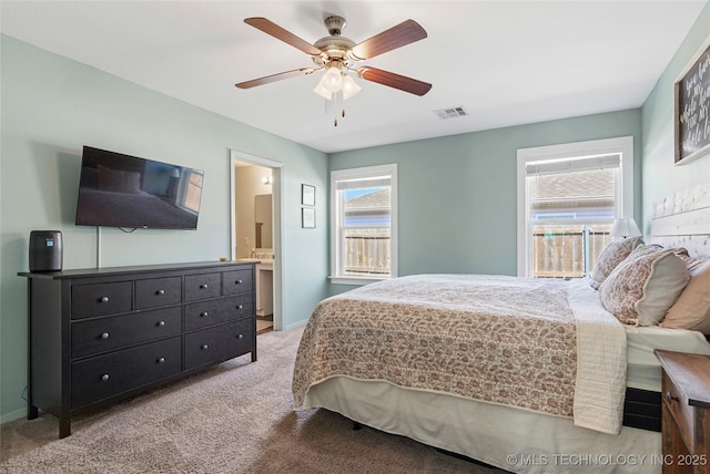 bedroom with visible vents, a ceiling fan, connected bathroom, baseboards, and light colored carpet