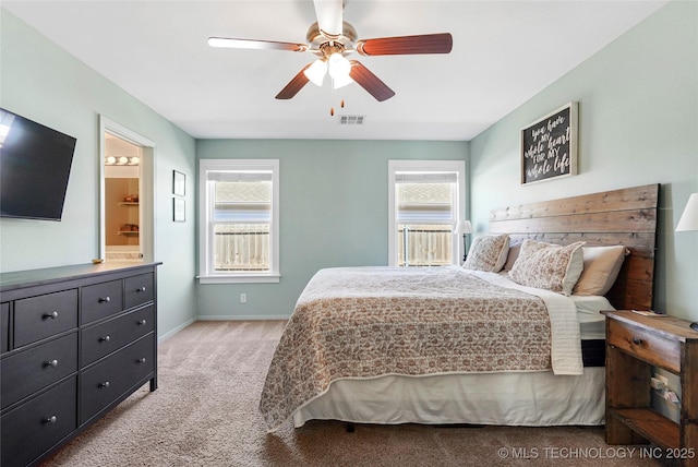 bedroom featuring visible vents, connected bathroom, baseboards, carpet flooring, and a ceiling fan