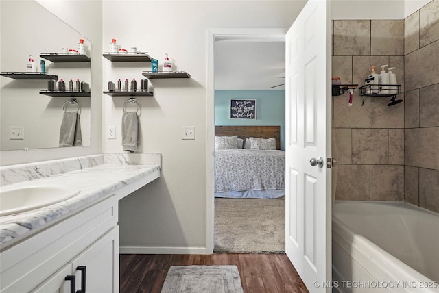 full bathroom with vanity, wood finished floors, baseboards, and connected bathroom