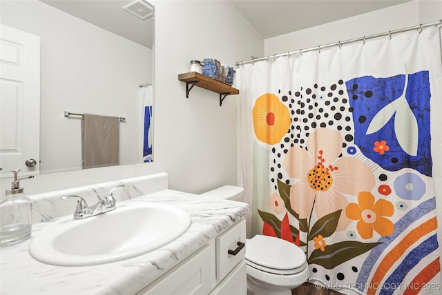 bathroom featuring visible vents, toilet, vanity, and a shower with shower curtain