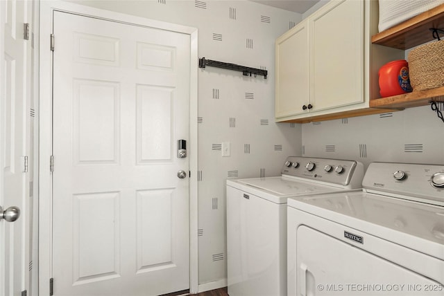 laundry area with washing machine and clothes dryer and cabinet space