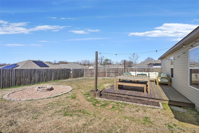 view of yard featuring an outdoor living space with a fire pit, a wooden deck, and a fenced backyard