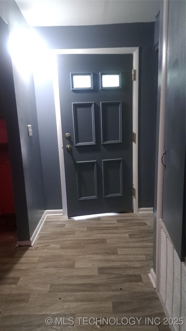 doorway to outside with visible vents, baseboards, and wood finished floors