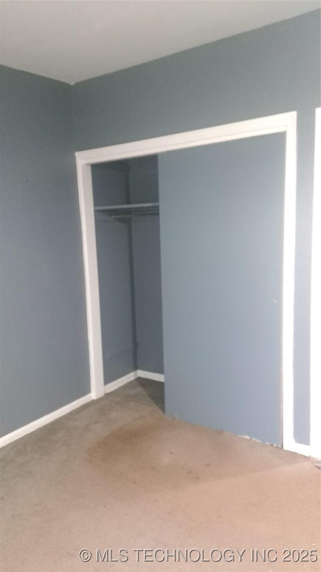 unfurnished bedroom featuring carpet floors and a closet